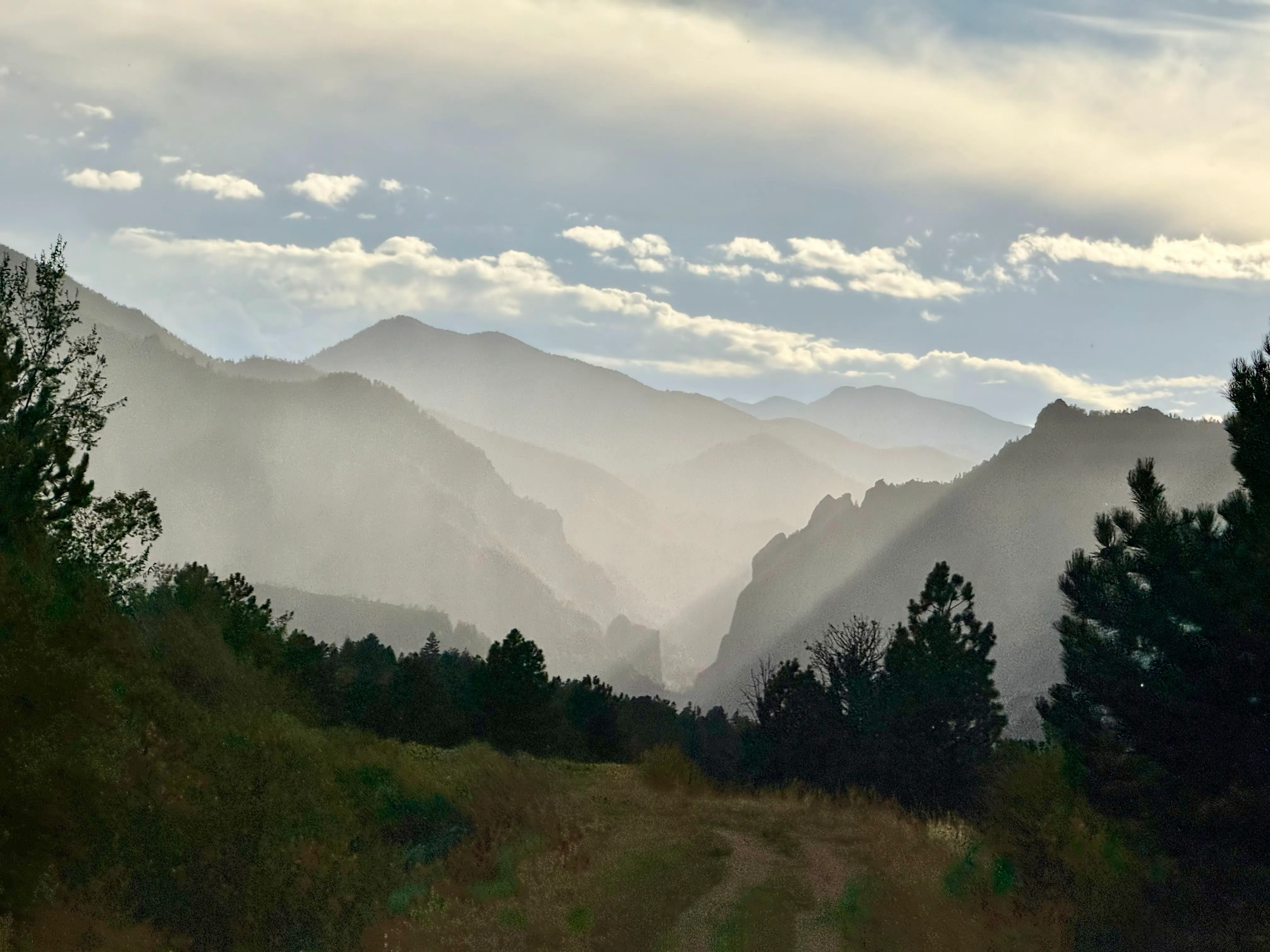 Layered foothills in haze above a two-track, looking west out of Boulder