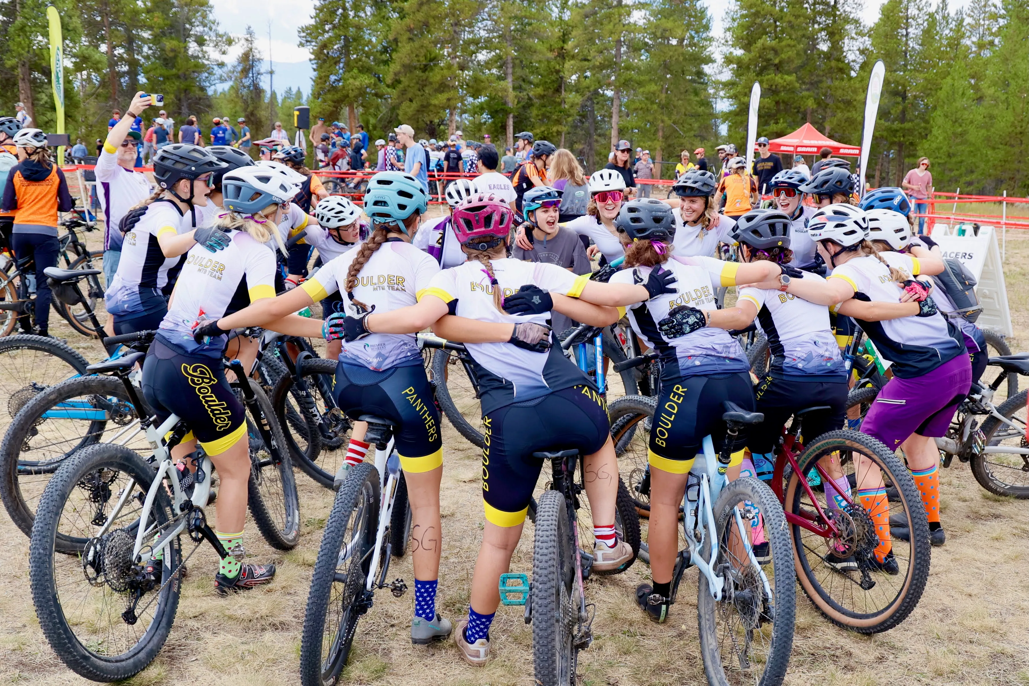 Boulder High riders in a team huddle on bikes before a race